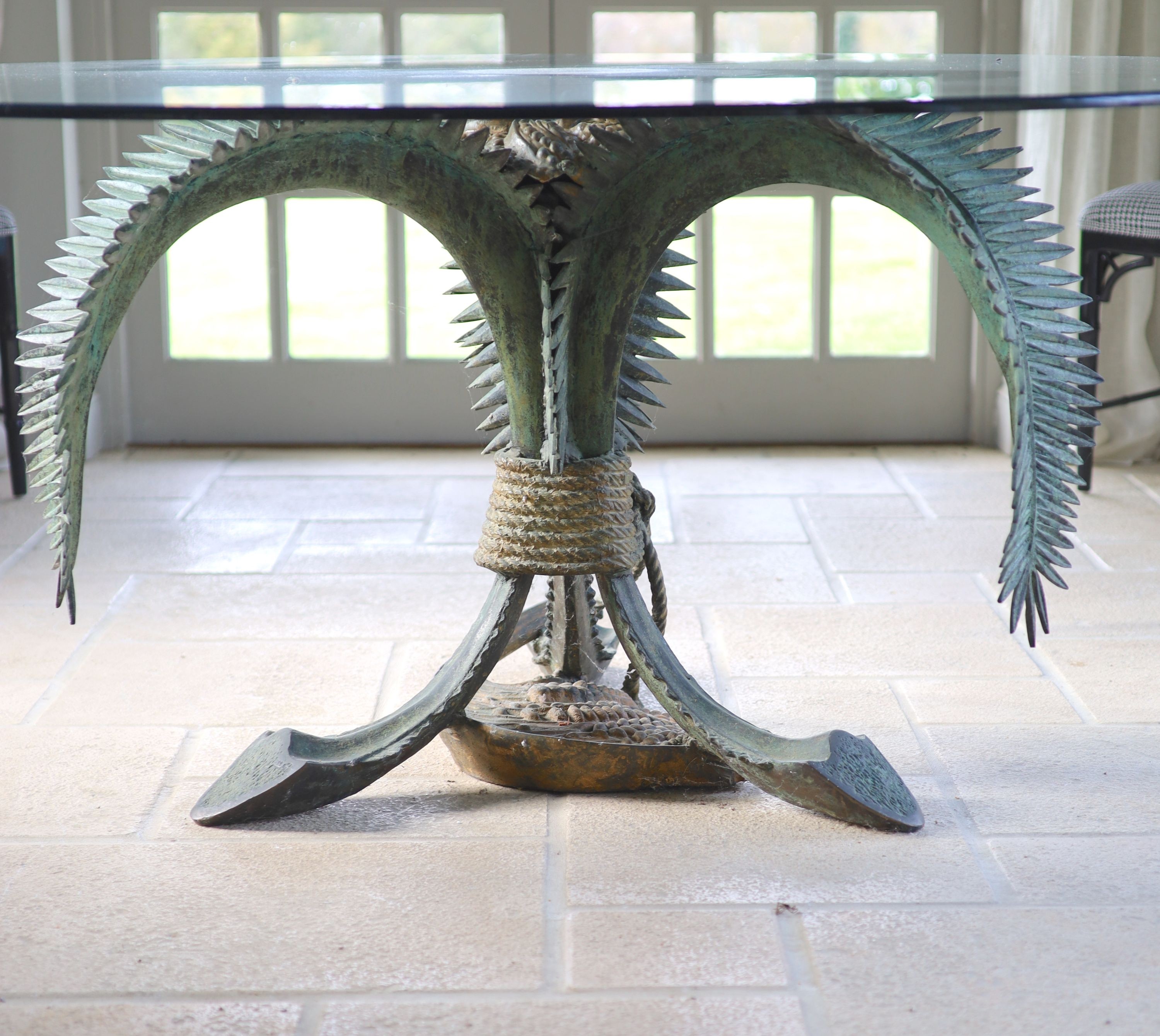 A patinated bronze and glass palm leaf centre table, the circular top 165cm height 75cm